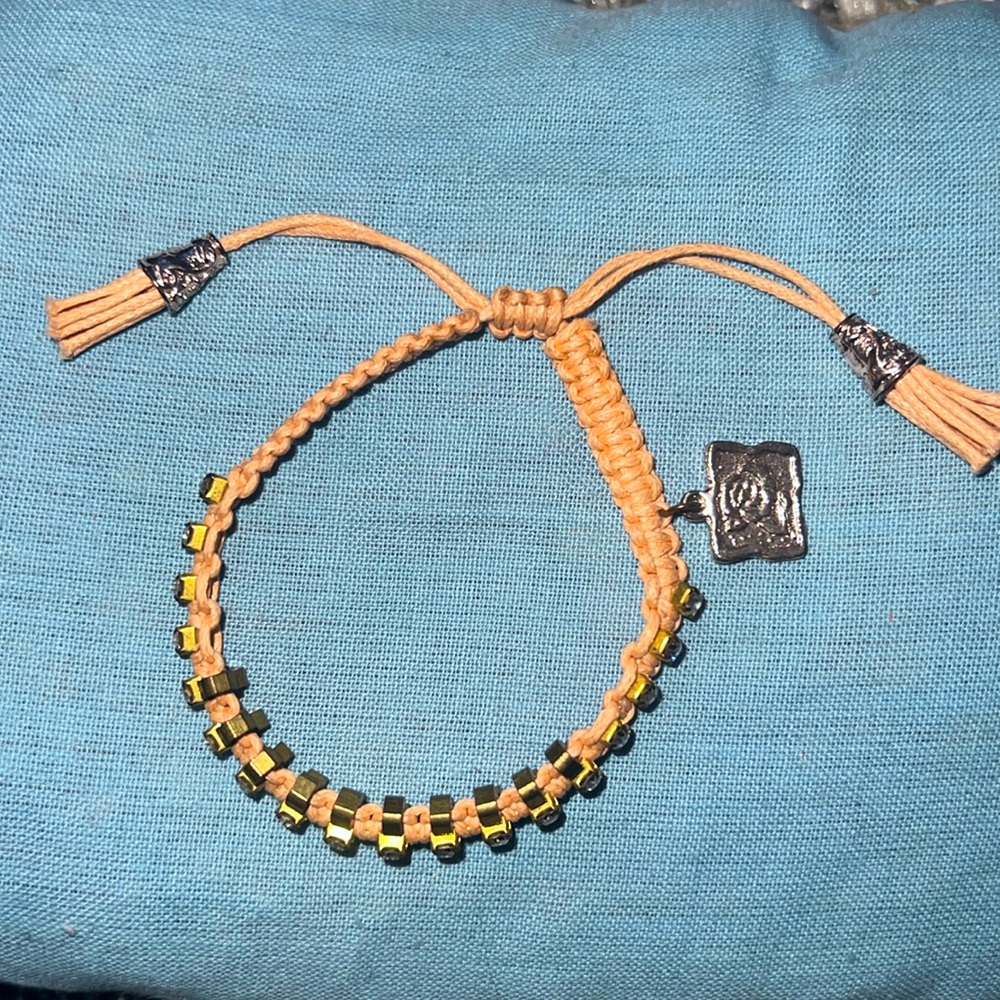 This is a peach colored bracelet with gold accents.